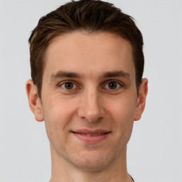 Joyful white young-adult male with short  brown hair and grey eyes