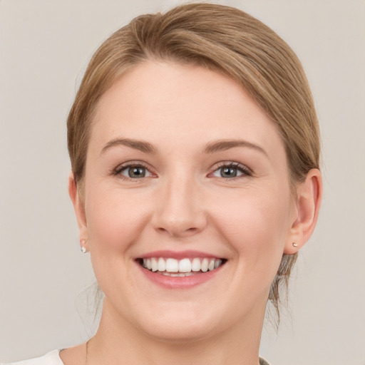 Joyful white young-adult female with medium  brown hair and grey eyes