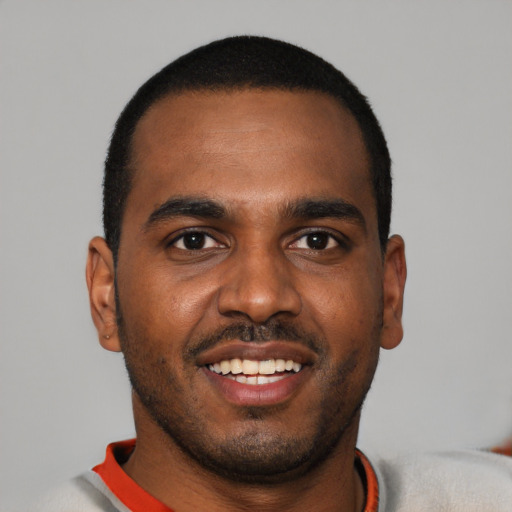 Joyful black young-adult male with short  black hair and brown eyes