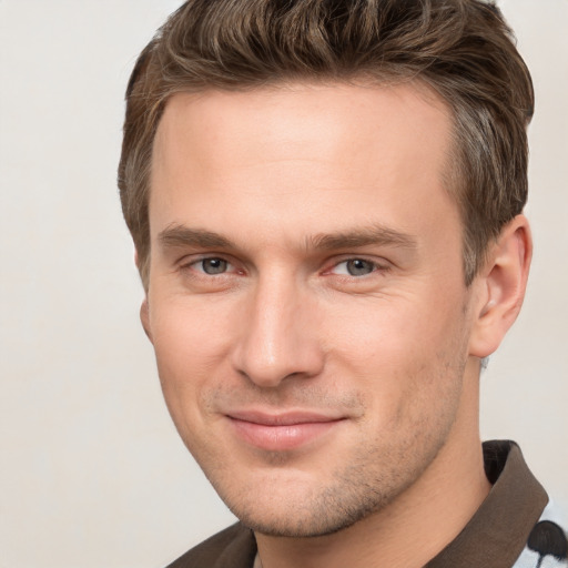 Joyful white young-adult male with short  brown hair and grey eyes