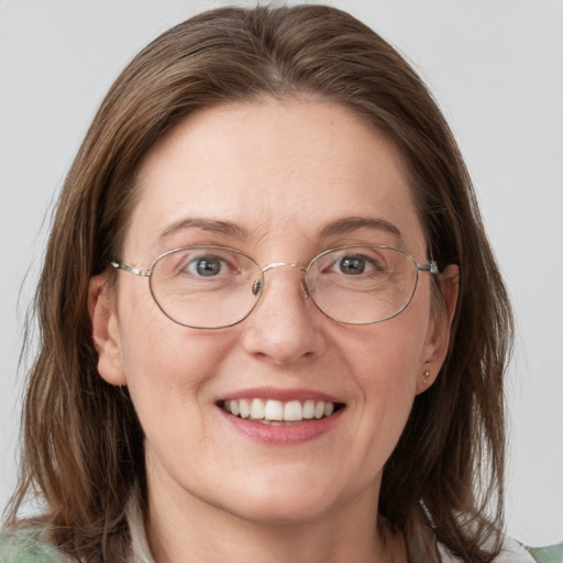 Joyful white adult female with medium  brown hair and blue eyes