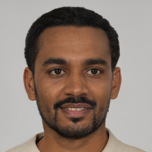 Joyful black young-adult male with short  black hair and brown eyes