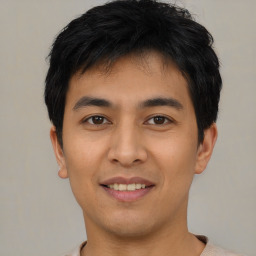 Joyful asian young-adult male with short  black hair and brown eyes