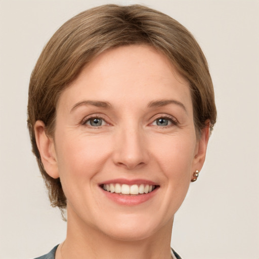 Joyful white young-adult female with medium  brown hair and grey eyes