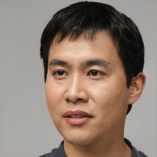 Joyful asian young-adult male with short  black hair and brown eyes