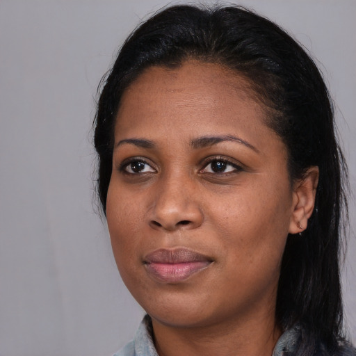 Joyful black young-adult female with long  black hair and brown eyes