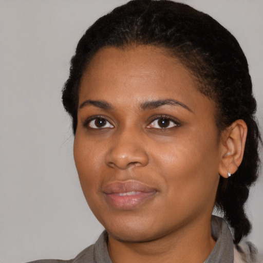 Joyful black young-adult female with short  black hair and brown eyes
