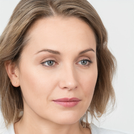 Joyful white young-adult female with medium  brown hair and blue eyes