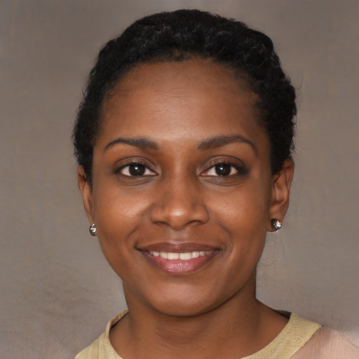 Joyful black young-adult female with short  black hair and brown eyes
