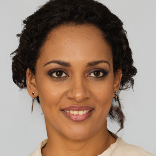 Joyful black young-adult female with medium  brown hair and brown eyes