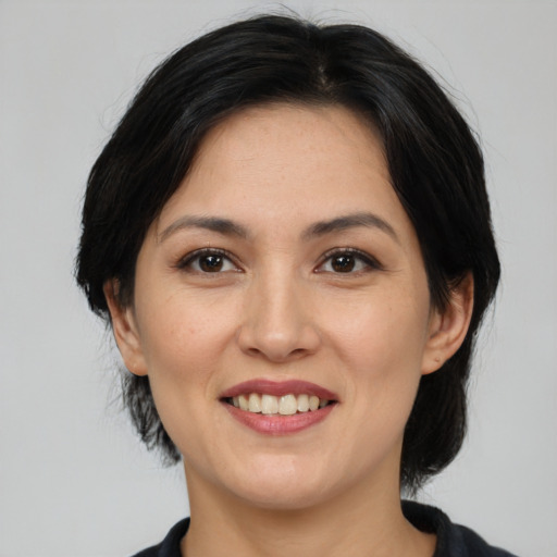 Joyful asian adult female with medium  black hair and brown eyes