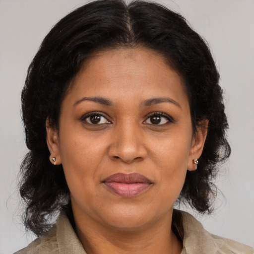 Joyful black adult female with medium  brown hair and brown eyes