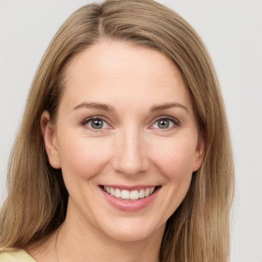 Joyful white young-adult female with long  brown hair and grey eyes