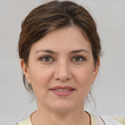 Joyful white young-adult female with medium  brown hair and grey eyes