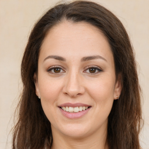Joyful white young-adult female with long  brown hair and brown eyes