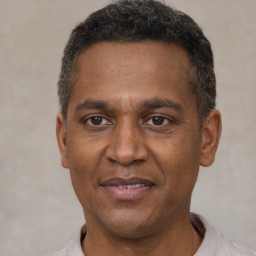 Joyful black adult male with short  brown hair and brown eyes