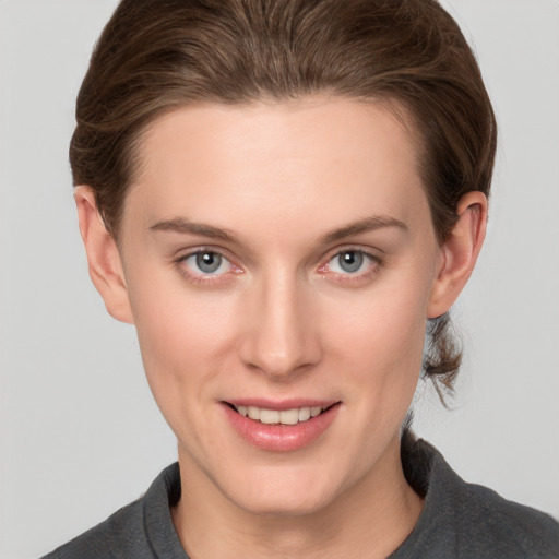 Joyful white young-adult female with short  brown hair and grey eyes