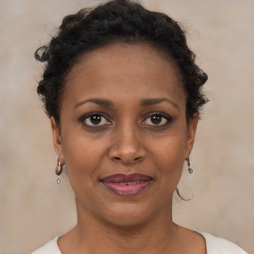 Joyful black young-adult female with short  brown hair and brown eyes