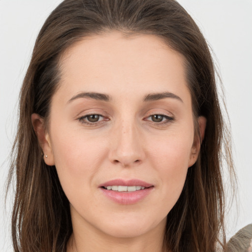 Joyful white young-adult female with long  brown hair and brown eyes