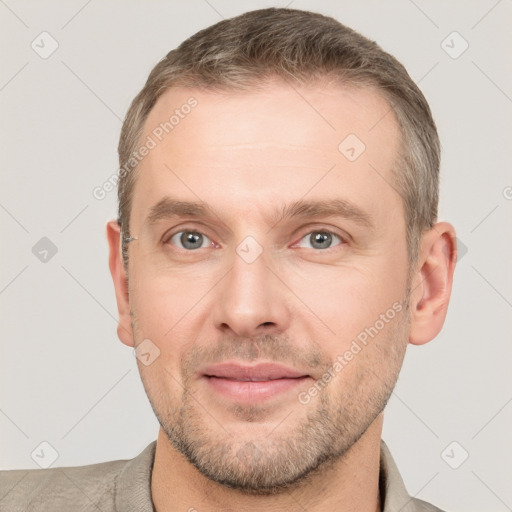 Joyful white adult male with short  brown hair and grey eyes