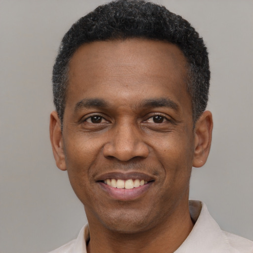 Joyful black adult male with short  black hair and brown eyes