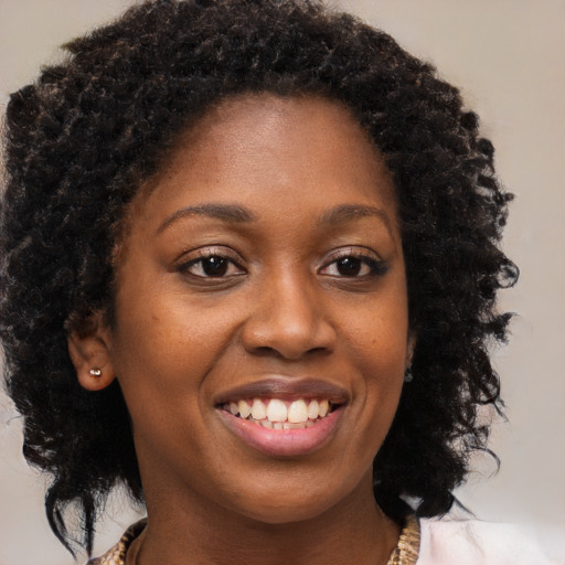 Joyful black young-adult female with medium  brown hair and brown eyes