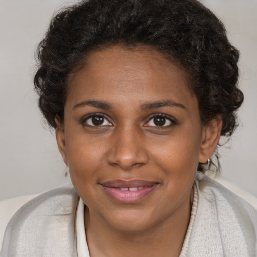 Joyful black young-adult female with short  brown hair and brown eyes