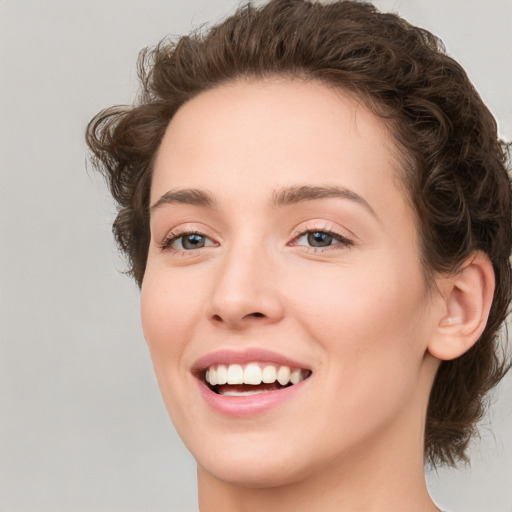 Joyful white young-adult female with medium  brown hair and green eyes