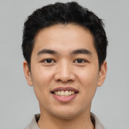 Joyful asian young-adult male with short  brown hair and brown eyes