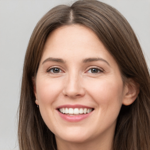 Joyful white young-adult female with long  brown hair and grey eyes