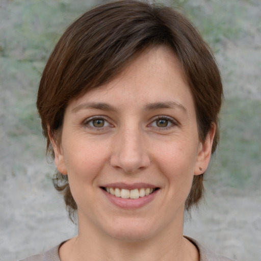 Joyful white young-adult female with medium  brown hair and grey eyes