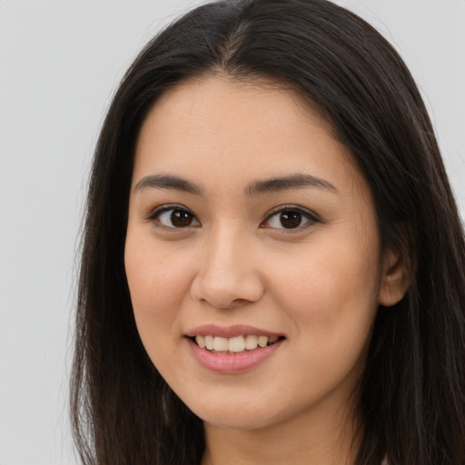 Joyful asian young-adult female with long  brown hair and brown eyes