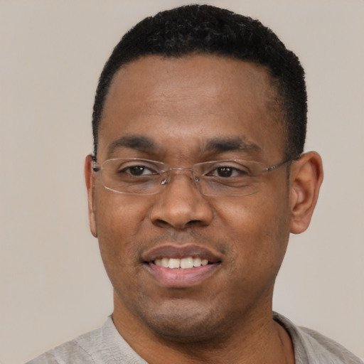 Joyful black adult male with short  black hair and brown eyes