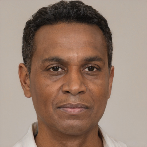 Joyful black adult male with short  brown hair and brown eyes