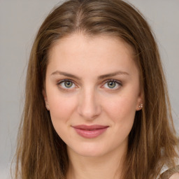 Joyful white young-adult female with long  brown hair and green eyes