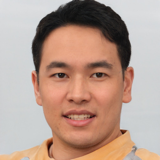 Joyful asian young-adult male with short  brown hair and brown eyes