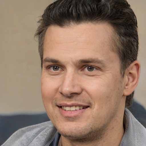 Joyful white adult male with short  brown hair and brown eyes