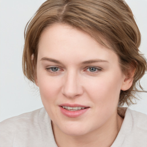 Joyful white young-adult female with medium  brown hair and blue eyes