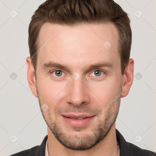 Joyful white young-adult male with short  brown hair and grey eyes