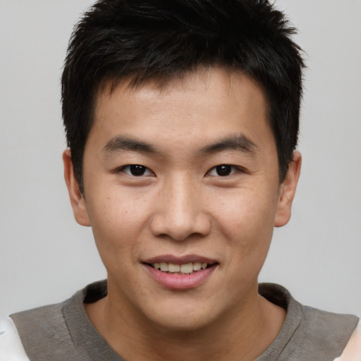 Joyful asian young-adult male with short  brown hair and brown eyes
