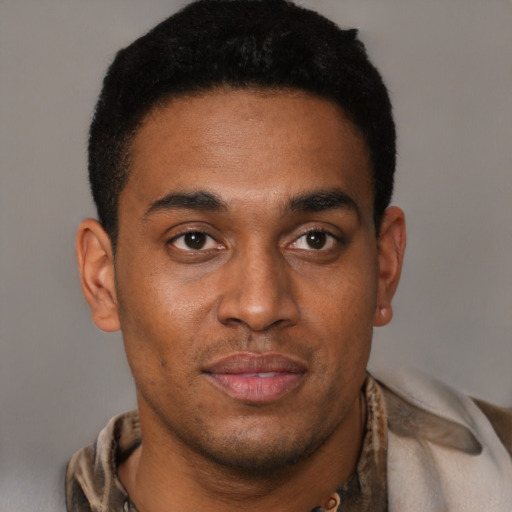 Joyful black young-adult male with short  black hair and brown eyes