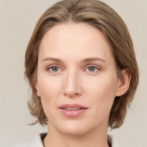 Joyful white young-adult female with medium  brown hair and grey eyes