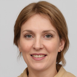 Joyful white adult female with medium  brown hair and grey eyes