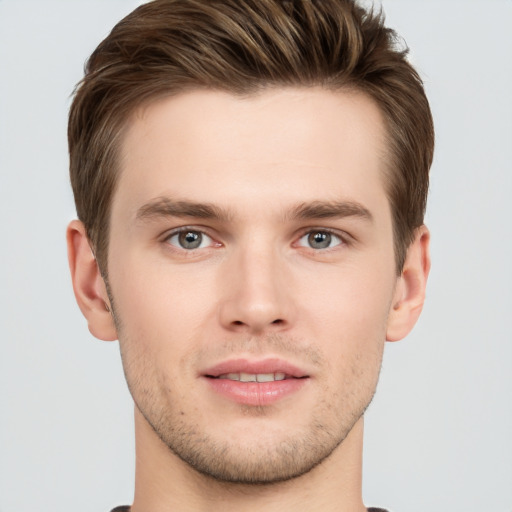 Joyful white young-adult male with short  brown hair and grey eyes