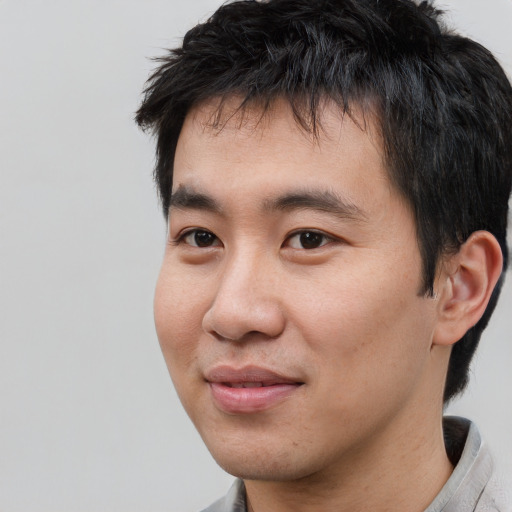 Joyful asian young-adult male with short  black hair and brown eyes