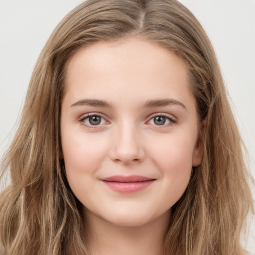 Joyful white child female with long  brown hair and brown eyes