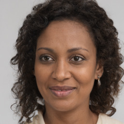 Joyful black adult female with medium  brown hair and brown eyes