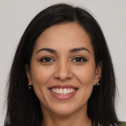 Joyful latino young-adult female with long  brown hair and brown eyes