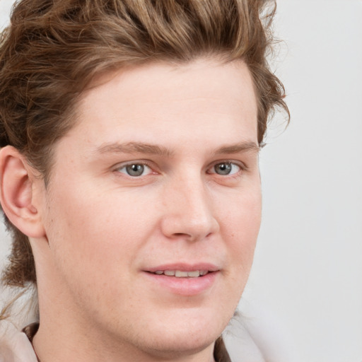 Joyful white young-adult male with short  brown hair and blue eyes