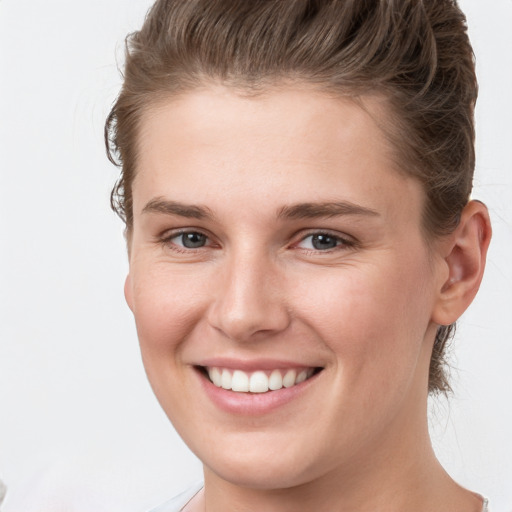 Joyful white young-adult female with short  brown hair and grey eyes